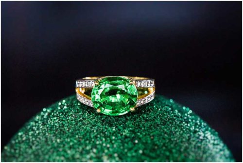 Emerald engagement ring on christmas ornament