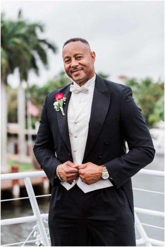 Groom in a black tux on boat South Florida Wedding