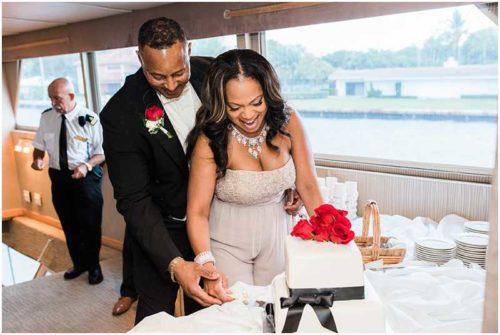 Laughing bride and groom cutting cake