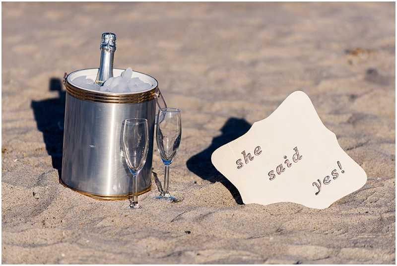 Champagne and sign for marriage proposal on beach