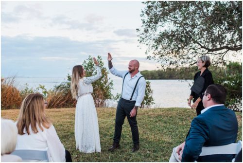 Bride and groom high five at Chart House waterfront wedding