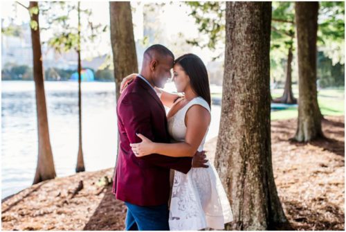 couple kissing in sun at Lake Eola engagement