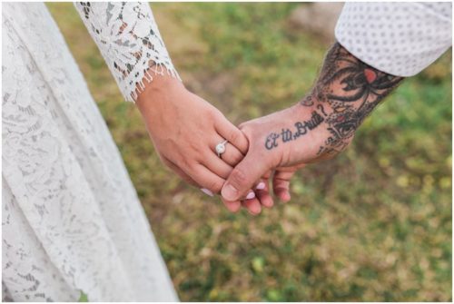 Bride and groom holding hands with tatoo at waterfront wedding at Chart House