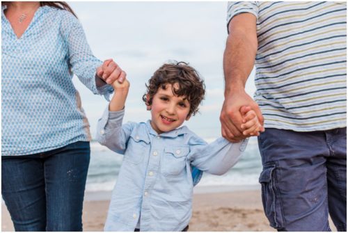 Melbourne Beach family photography boy holding hands with parents on beach photo by Liz Cowie Photography