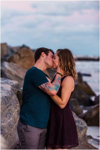 Couple kissing by rocks at Jetty Park Engagement