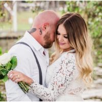 Bride and groom with bouquet at waterfront wedding at Chart House
