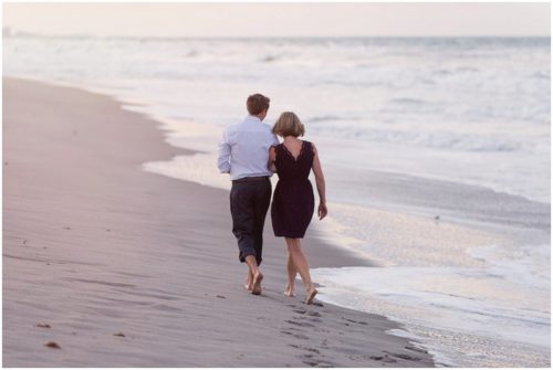 Couple walking down beach at sunset after Melbourne Beach Proposal