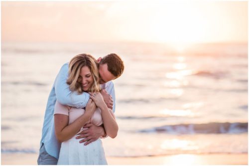 couple being silly couple walking down the beach during sunrise engagement on Melbourne Beach