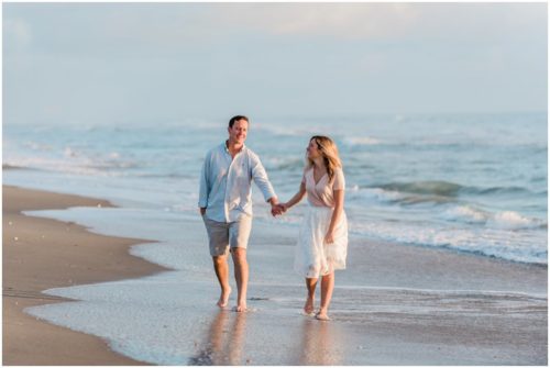 Girl pulling guy down beach couple walking down the beach during sunrise engagement on Melbourne Beach