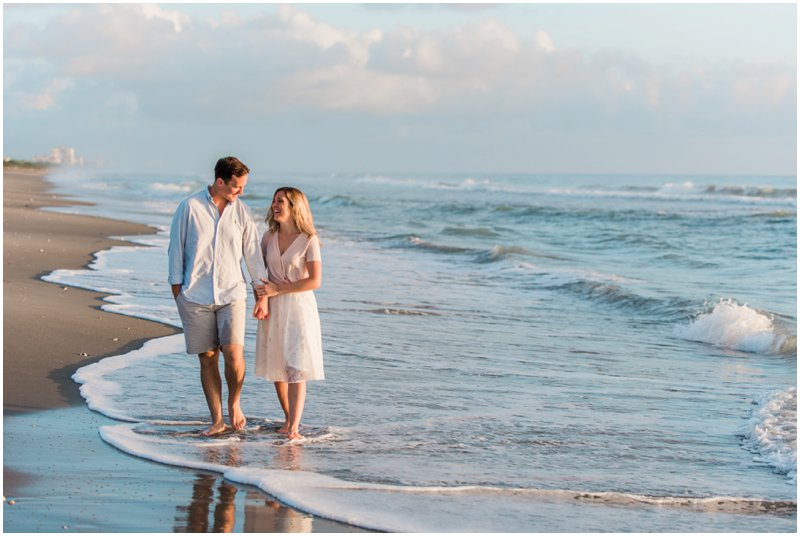 couple walking down the beach during sunrise engagement on Melbourne Beach