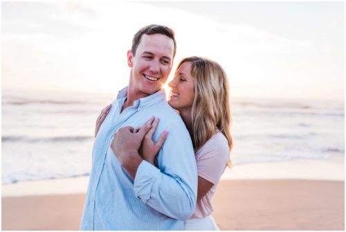couple laughing during sunrise engagement on Melbourne Beach