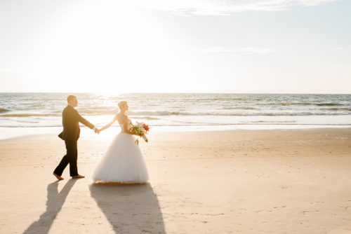 Melbourne Beach sunrise wedding groom walking with bride on beach photo by Liz Cowie Photography
