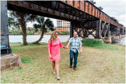 Couple walking under train bridge at downtown Melbourne engagement photography session