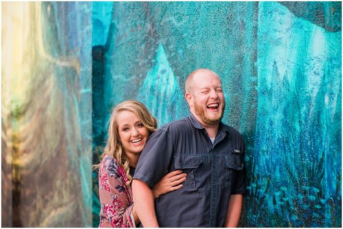 couple laughing behind blue wall at Melbourne engagement photography session