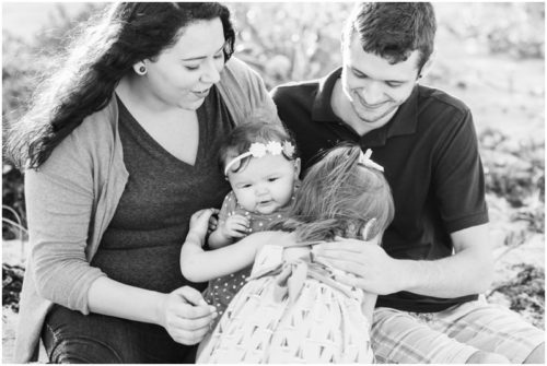 family hugging by dunes during Melbourne Beach Family Photography session