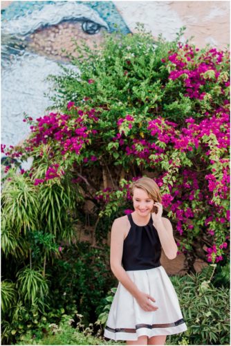 Girl in front of bird mural and flowers during Sweet 16 portraits in downtown Eau Gallie