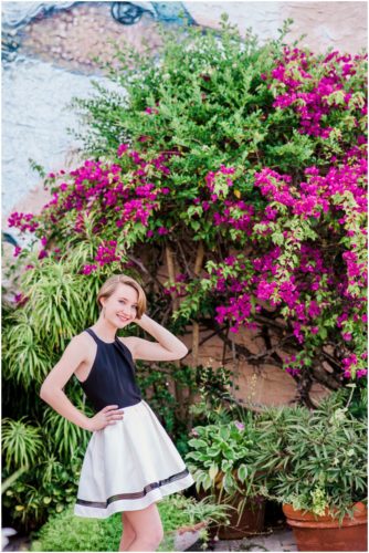 Girl in front of bird mural and flowers during Sweet 16 portraits in downtown Eau Gallie