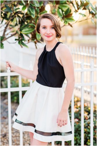 Girl holding fence during Sweet 16 portraits in downtown Eau Gallie