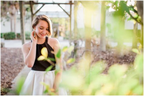 Girl behind bushes during Sweet 16 portraits in downtown Eau Gallie