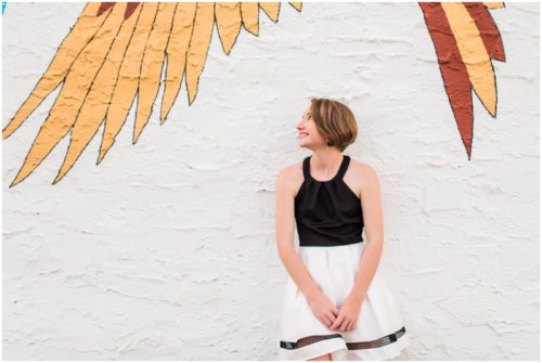 Girl under bird mural during Sweet 16 portraits in downtown Eau Gallie