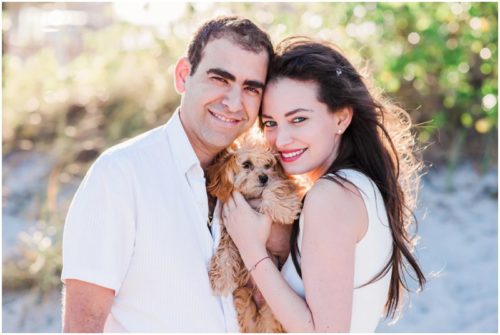 beautiful light on beach with couple holding dog