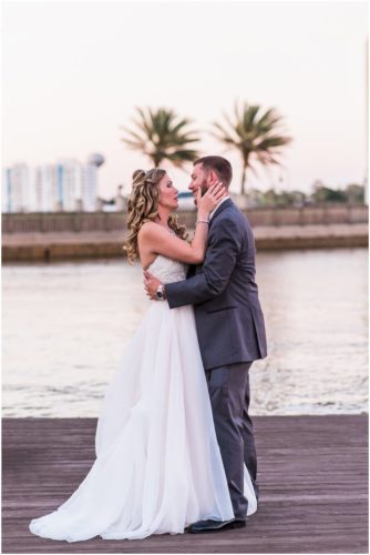 Bride holding groom's face Bride and groom walking on dock at Crystal Ballroom Wedding