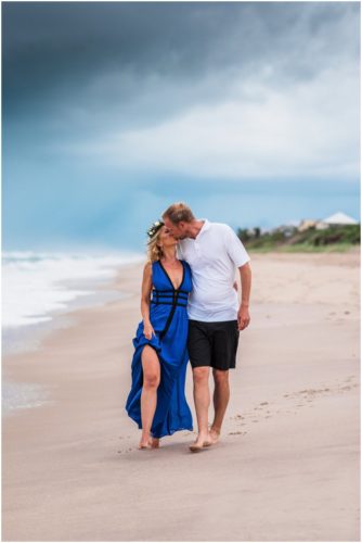 Couple kissing on beach with storm approaching during Melbourne Beach engagement session