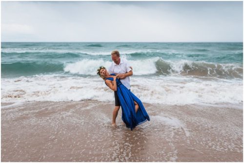 Groom dipping bride in ocean during Melbourne Beach Florida engagement session