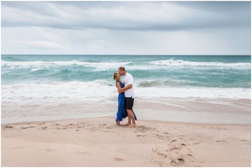 Kissing by the ocean during Melbourne Beach engagement session