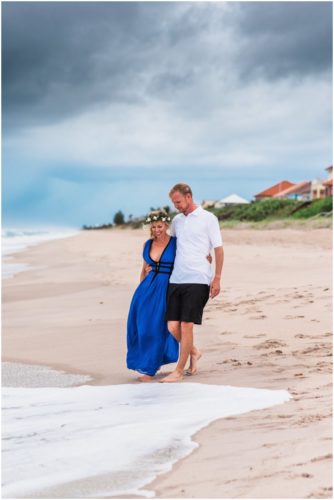 Couple walking toward water during Melbourne Beach engagement session