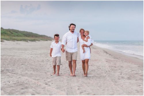 Family walking hand in hand down beach during Melbourne Beach Family Portraits