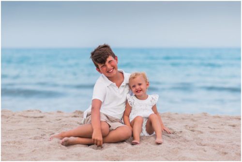 Siblings sitting together on beach during Melbourne Beach Family Portraits