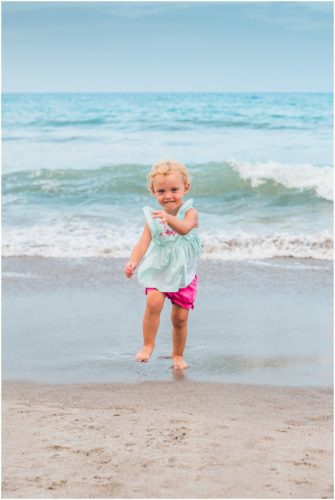 cute 2 year old in pink shorts running during Melbourne Beach family portraits