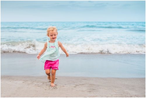 cute 2 year old in pink shorts running during Melbourne Beach family portraits