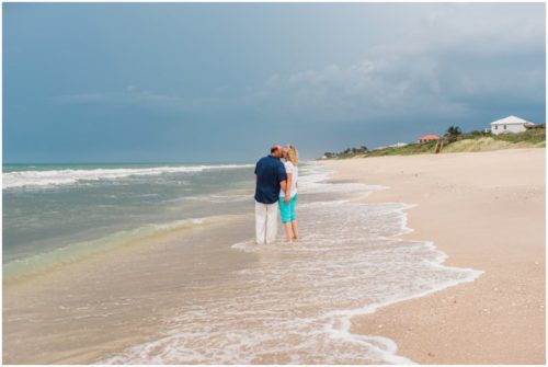 Mom and dad kissing during their fun family beach portraits