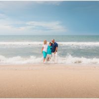 Family walking with arms around each other during their fun family beach portraits