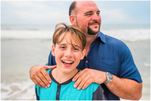 Son and dad laughing during their fun family beach portraits