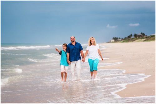Family spotting fish jumping in water during their fun family beach portraits