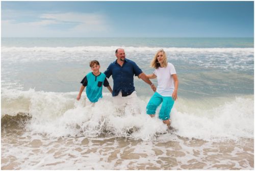 Wave crashing on family during their fun family beach portraits
