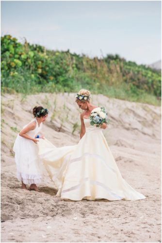 Brides daughter fixing her dress on beach during gorgeous Melbourne Beach wedding