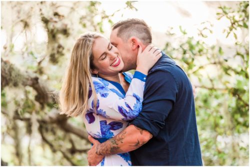 Girl laughing and hugging under the oak trees during Vero Beach engagement