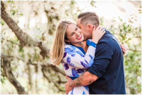 Girl laughing and hugging under the oak trees during Vero Beach engagement