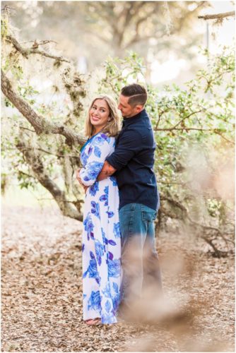Couple hugging under the oak trees during Vero Beach engagement
