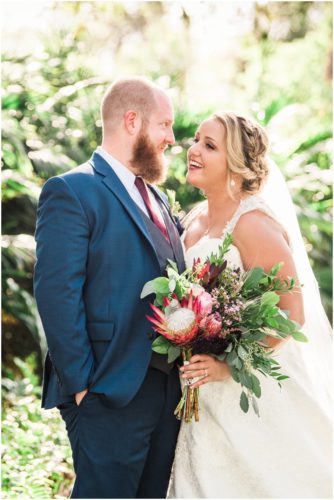 Bride looking at groom holding asymetrical bouquet at Up the Creek Farms Wedding
