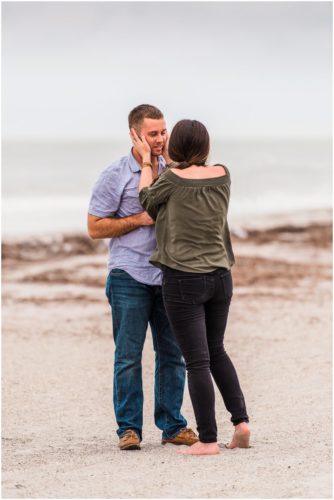 Girl holding his face during Cocoa Beach Proposal