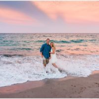 Waves crashing on couple during beach engagement session in Vero Beach
