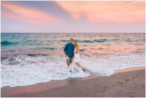 Waves crashing on couple during beach engagement session in Vero Beach