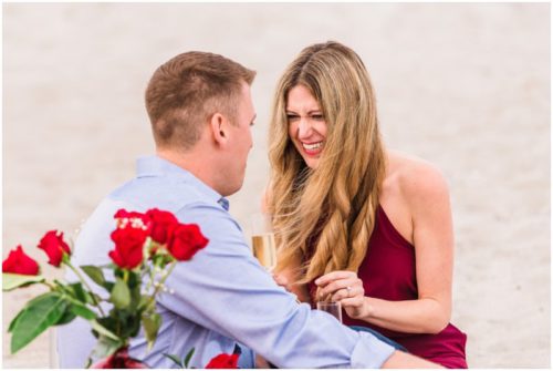 Couple toasting on beach after getting engaged during Cocoa Beach Surprise Proposal