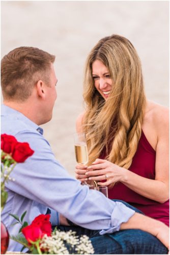 Couple toasting on beach after getting engaged during Cocoa Beach Surprise Proposal