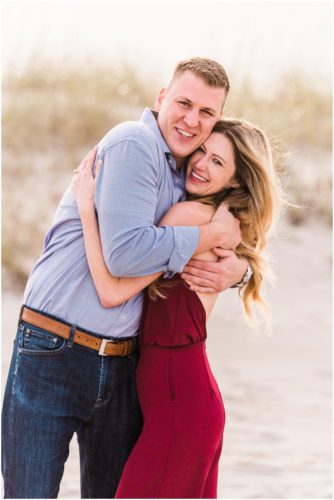 Couple hugging by dunes during Cocoa Beach Surprise Proposal